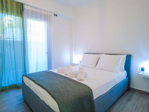 a bedroom with a bed with white sheets and a window at ChriLenia Aparments in Kalamata