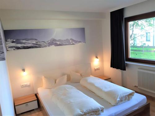 1 dormitorio con 1 cama con 2 almohadas en Appartement Hohe Tauern & Großvenediger, en Mittersill
