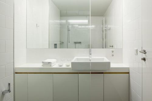 a white bathroom with a sink and a mirror at Hotel Wetzlgut in Bad Gastein