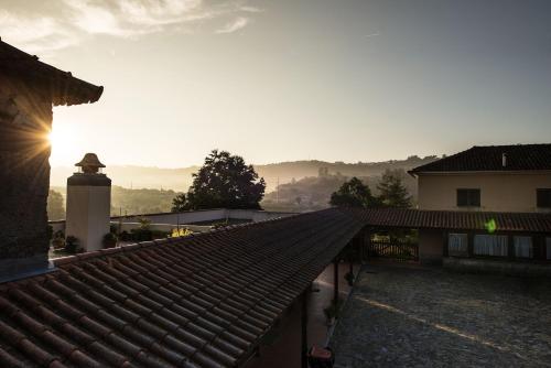 a roof of a house with the sun in the sky at Stone Farm Hostel in Felgueiras