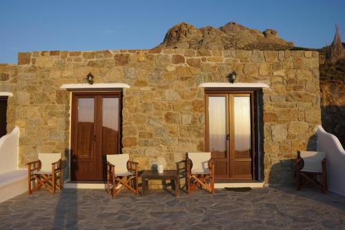 a stone wall with chairs and a table in front of a building at Casa Borealis in Naxos Chora