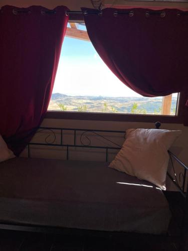 a bed in a room with a large window at MonteSoprano Agriturismo - Resort - Spa - Gym -Camping - Suite in Capizzi