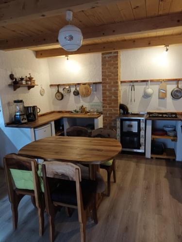 cocina con mesa de madera y sillas en Apartman Latin 2 en Plaški