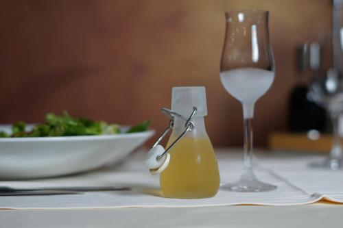 a table with a glass of wine and a plate of food at Uva Nestum Wine & SPA in Gotse Delchev