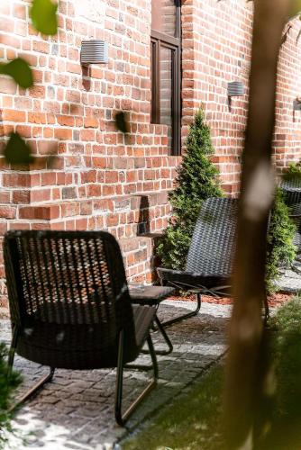 two benches sitting in front of a brick building at Great Polonia The Granary La Suite Hotel in Wrocław