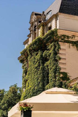 a building covered in green ivy next to a building at Great Polonia The Granary La Suite Hotel in Wrocław