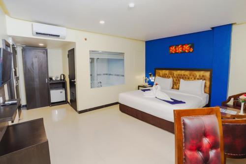 a bedroom with a large bed and a blue wall at Parkside Star Hotel Jayapura in Jayapura
