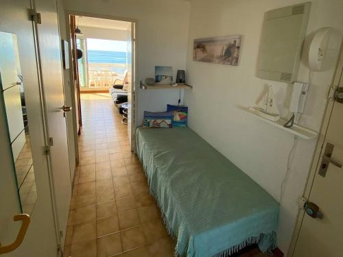 une chambre avec un lit vert dans une chambre avec vue dans l'établissement Palavas : T2 Cabine en Front de Mer avec Balcon et Parking, Proche Centre et Commerces - FR-1-559-11, à Palavas-les-Flots
