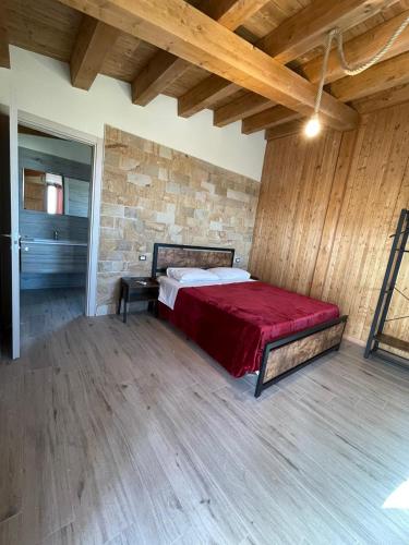 a bedroom with a bed in a room with a brick wall at MonteSoprano Agriturismo - Resort - Spa - Gym -Camping - Suite in Capizzi
