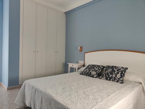 sypialnia z białym łóżkiem i dwiema poduszkami w obiekcie CHALET VILLA Los HIPOCAMPOS w mieście Cullera