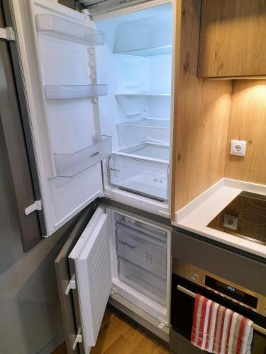 an empty refrigerator with its door open in a kitchen at White Design Apartment in Aveiro
