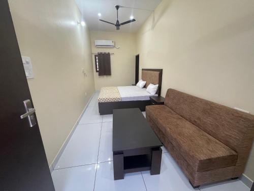 a small room with a bed and a couch in it at BLD Restaurant And Home Stay in Dehradun