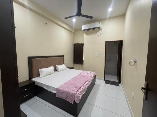 a bedroom with a bed with a pink blanket at BLD Restaurant And Home Stay in Dehradun