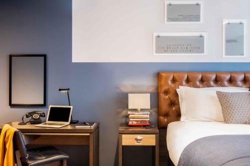 a bedroom with a bed and a desk at Hotel Indigo Manchester - Victoria Station, an IHG Hotel in Manchester