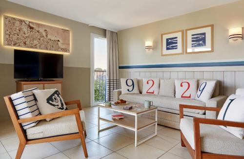 a living room with a couch and a table at Résidence Pierre & Vacances Premium Le Coteau et la Mer in Tréboul
