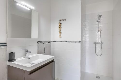 a white bathroom with a sink and a shower at Maison moderne pour 4 personnes a Saint-Gildas-de-Rhuys in Saint-Gildas-de-Rhuys