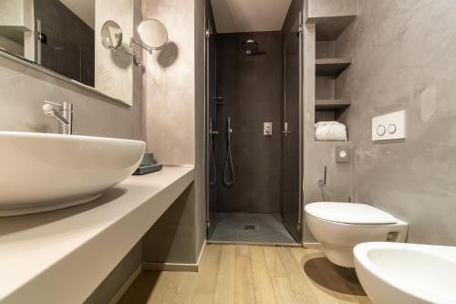 un bagno con lavandino, WC e doccia di Hotel Parco a Milano Marittima
