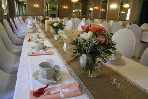 a long table with flowers in a room with chairs at Hotel-Gasthof Zur Post in Velburg