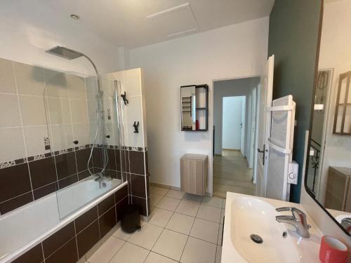 La salle de bains est pourvue d'une baignoire, d'un lavabo et d'une baignoire. dans l'établissement Proche Paris et Disney Maison 90 M2 CLIMATISÉ bord de Marne, à Gournay-sur-Marne