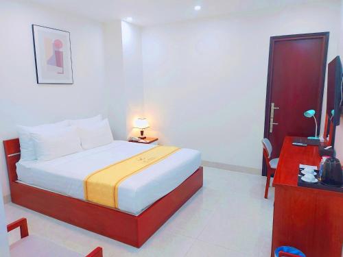 a hotel room with a bed and a television at Khách Sạn Lạc Hồng Mỹ Tho - Lac Hong My Tho Hotel in My Tho