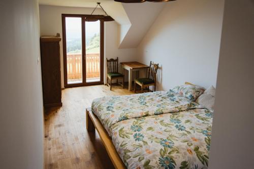 a bedroom with a bed and a desk with a window at Frešer Farm Accommodation 