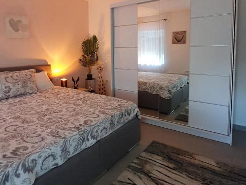 sypialnia z łóżkiem i dużym lustrem w obiekcie Afrodita apartment w mieście Vrdnik