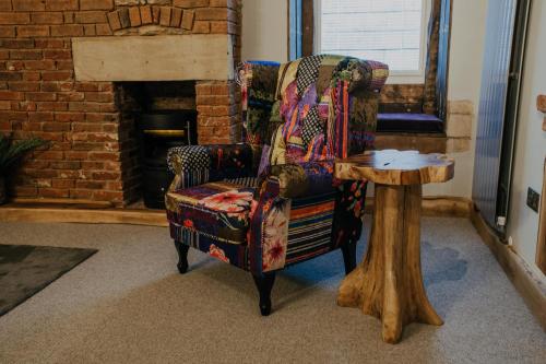 a chair and a table in a room with a fireplace at Urban Lofts in Melksham