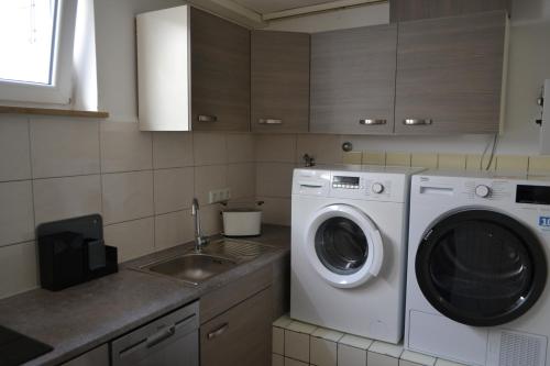 a kitchen with a washing machine and a sink at Monteurenwohnung im Untergeschoss mit Tageslicht in Bad Urach