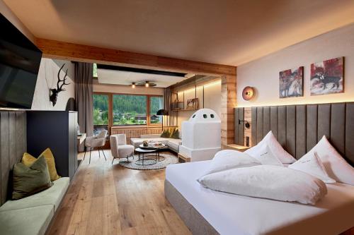 a bedroom with a bed and a living room at Relais&Châteaux Spa-Hotel Jagdhof in Neustift im Stubaital