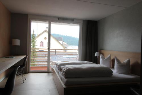Una cama o camas en una habitación de Hotel des Alpes