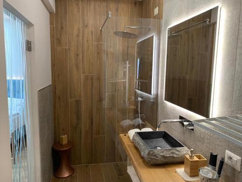 a bathroom with a shower with a sink and a mirror at Albergo Ristorante Montebaldo in Limone sul Garda