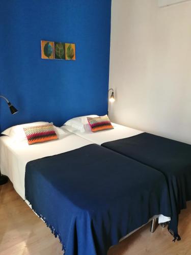 a bed in a room with a blue wall at Evora Inn in Évora