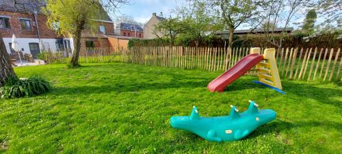 a childs playground with a slide in a yard at Au coquelicot : gîte cosy pour 8 pers. avec jardin in Ath