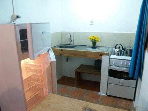 a small kitchen with a sink and a stove at La Joya del Diablo in Punta Del Diablo