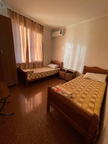 um pequeno quarto com 2 camas e uma janela em Guest House Passiflora პასიფლორა em Grigoleti