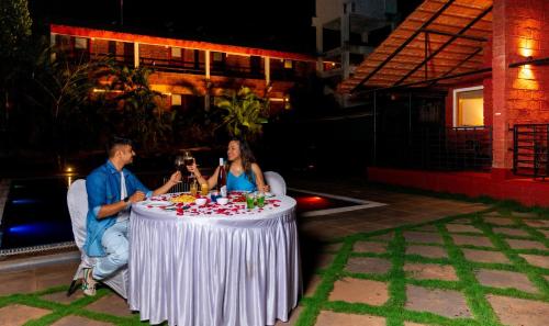 a man and a woman sitting at a table at Lotus an Eco Beach Resort Dapoli Murud in Dapoli