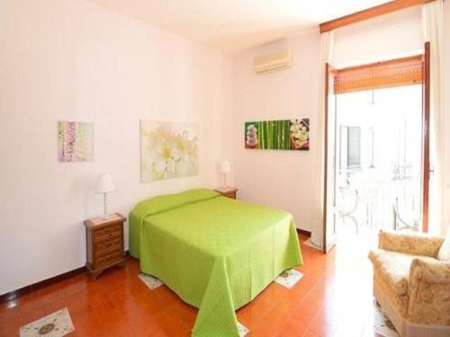 een slaapkamer met een groen bed en een bank bij Holiday Home Alessia n 3 ,Centro Storico di Taormina in Taormina
