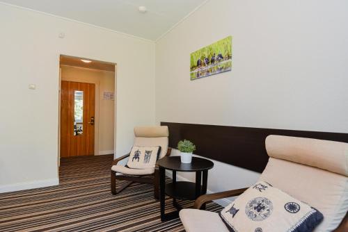 a living room with a couch and two chairs at Skalva Nida in Nida