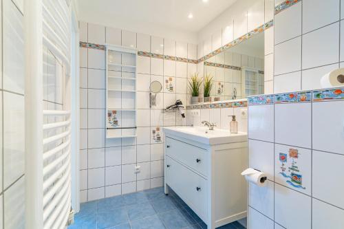 Baño blanco con lavabo y espejo en Appartement Nr 7 im Sonnenbad, en Sassnitz