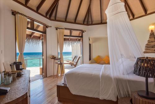 een slaapkamer met een bed en uitzicht op de oceaan bij Drift Thelu Veliga Retreat in Dhangethi