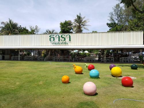 a group of balls on the grass in front of a building at Deluxe 1bedroom Hua Hin Seaview Beachfront Project in Ban Bo Fai