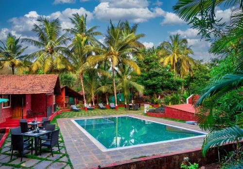 a resort with a swimming pool and palm trees at Lotus an Eco Beach Resort Dapoli Murud in Dapoli