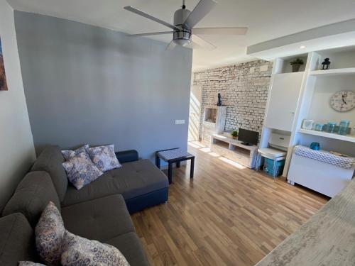 uma sala de estar com um sofá e uma ventoinha de tecto em Apartamento Mas Pinell B4 em Torroella de Montgrí