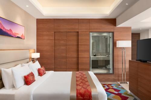 a bedroom with a large bed and a flat screen tv at Ramada Encore by Wyndham Kathmandu Thamel in Kathmandu