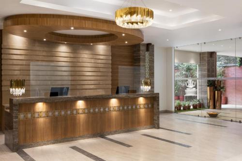 a hotel lobby with a reception desk and chandeliers at Ramada Encore by Wyndham Kathmandu Thamel in Kathmandu