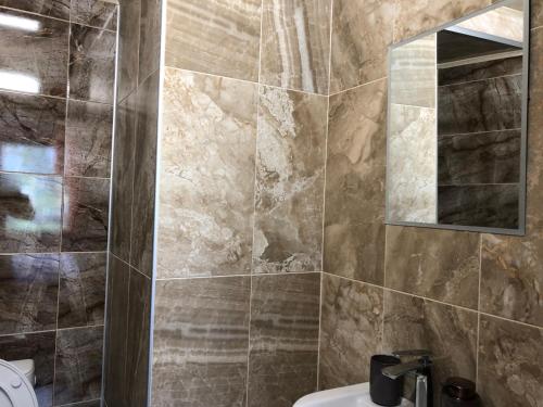 uma casa de banho com um lavatório e um espelho em Guest House Rest em Sapareva Banya