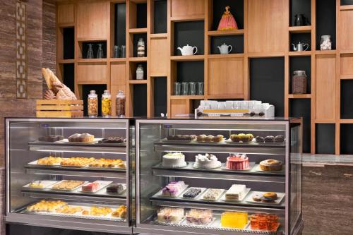 a display case filled with different types of pastries at Ramada Encore by Wyndham Kathmandu Thamel in Kathmandu