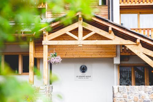 a building with a wooden roof with a flower box on it at Le Grand Aigle Hotel & Spa**** in La Salle-les-Alpes