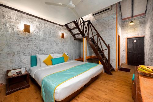 a bedroom with a large bed and a staircase at Lotus an Eco Beach Resort Dapoli Murud in Dapoli