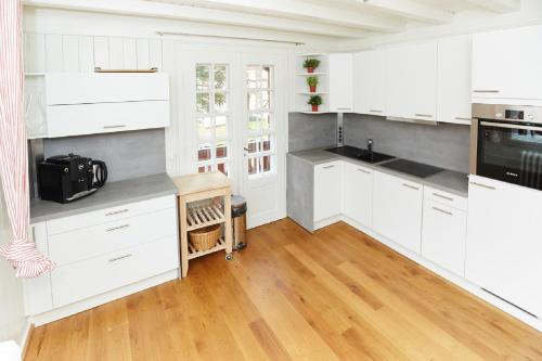 eine Küche mit weißen Schränken und Holzböden in der Unterkunft Haus Castell in Oberstdorf